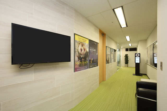 Passage from reception to the staff’s working area and the meeting room. Movie posters are arranged on the wall.
